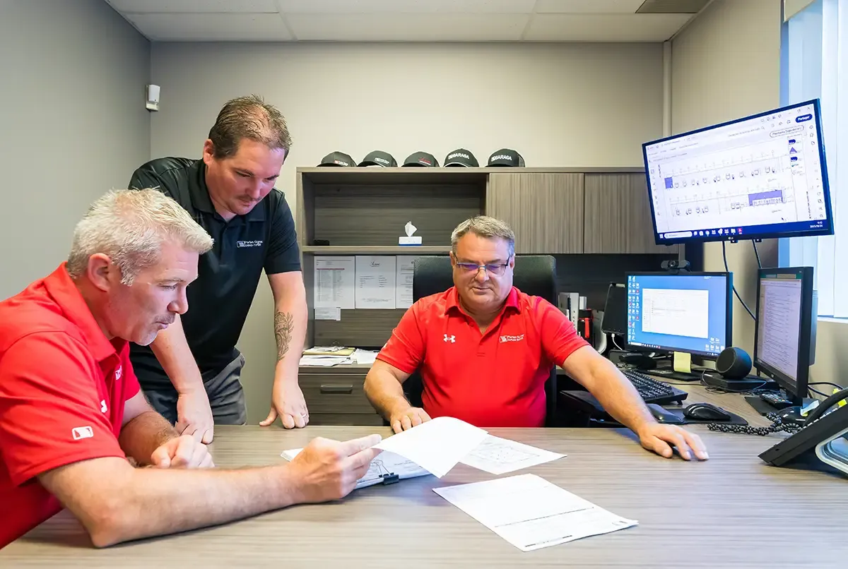 Travailleurs chez Portes Gignac devant un plan dans un bureau