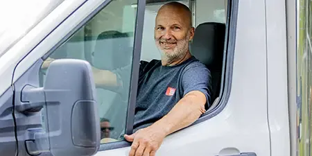 Deux techniciens de Portes Gignac assis à l'arrière de leur camion de service